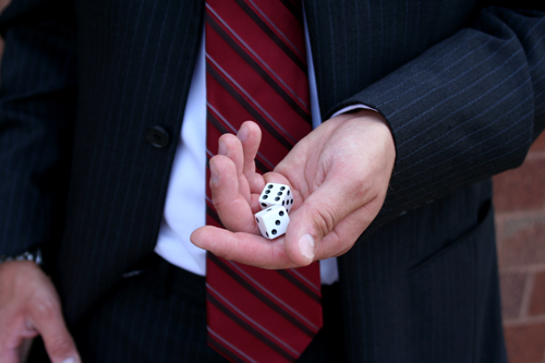 Man in suit rolling dice